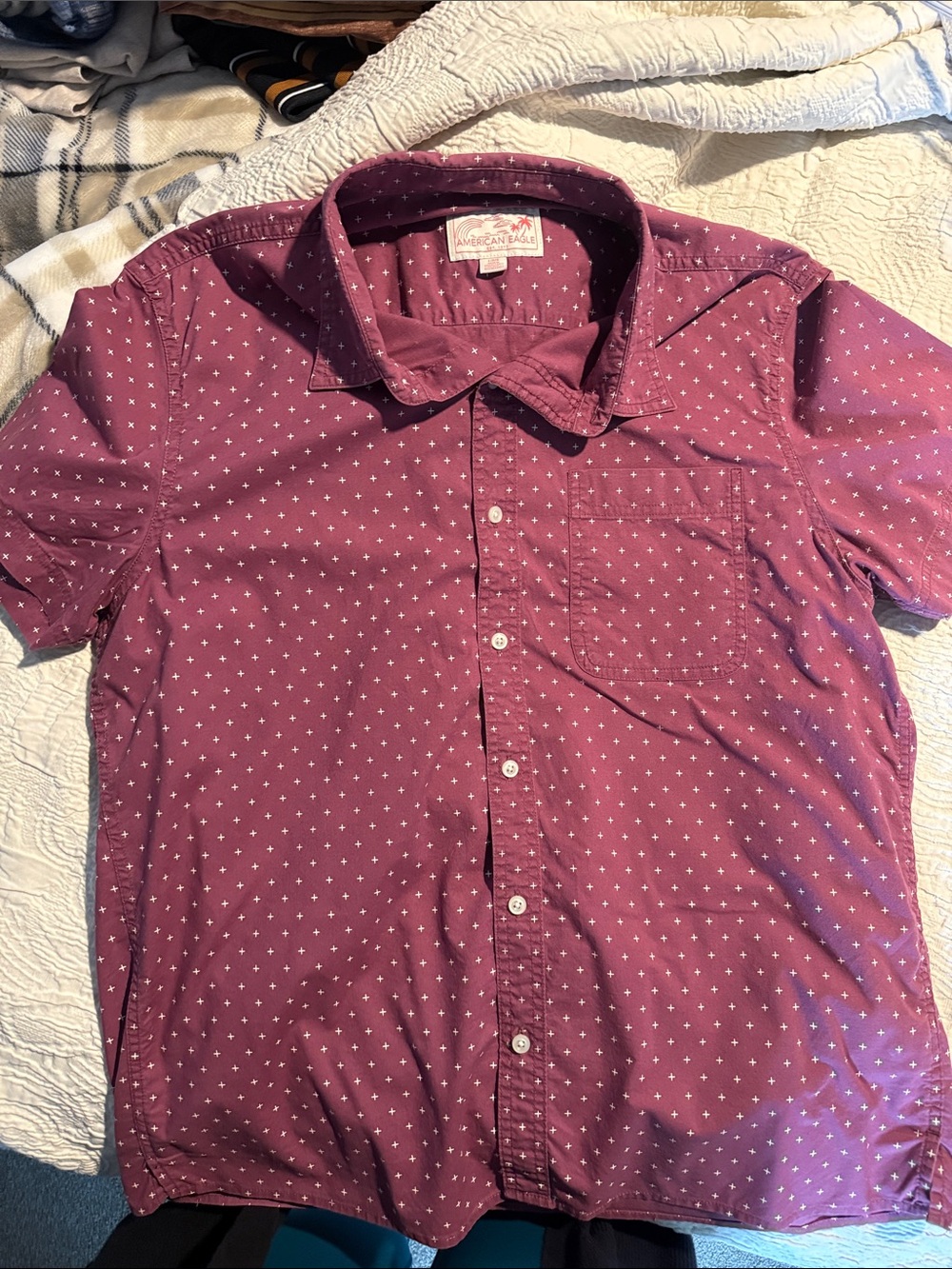 American Eagle Men’s Short Sleeved, Red Shirt with white plus sign pattern.